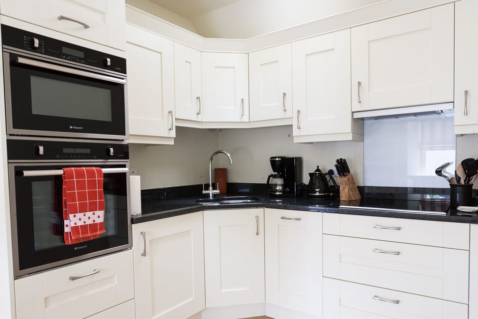 Kitchen with double oven, induction hob, fridge and  dishwasher