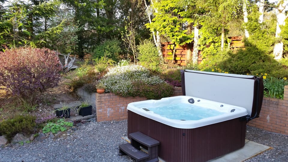 6 person hot tub with waterfall, changing lighting in landscaped rear garden