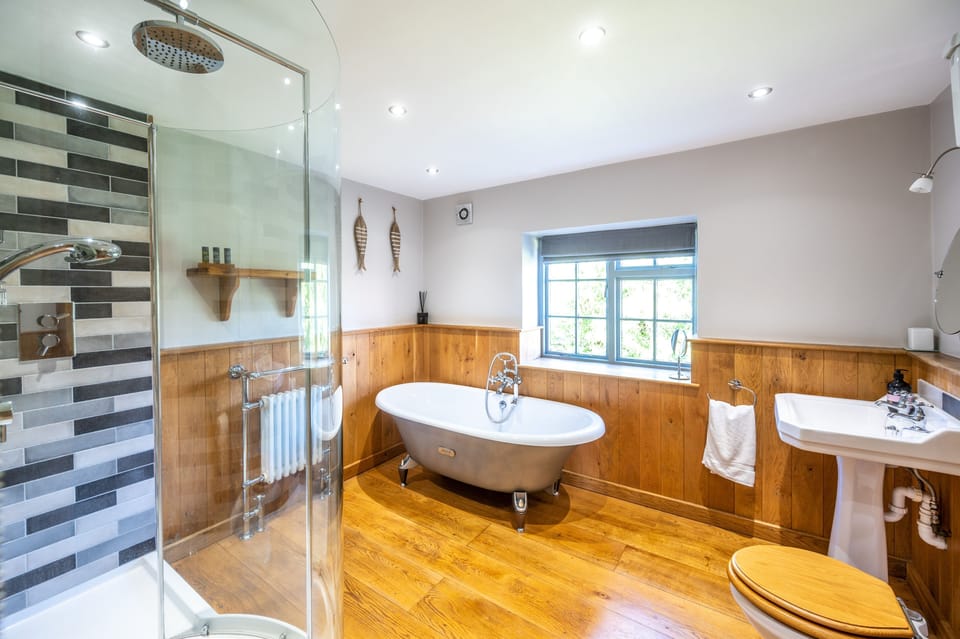 First floor:  Master bedroom en-suite bathroom with a shower and bath