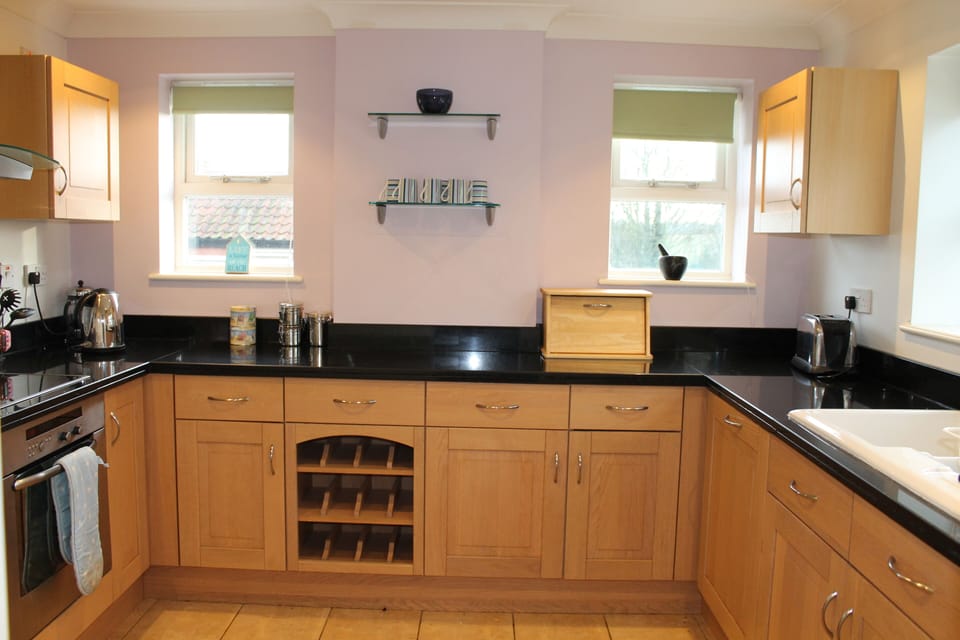 Kitchen with granite worktop boasting views over the garden and fields.