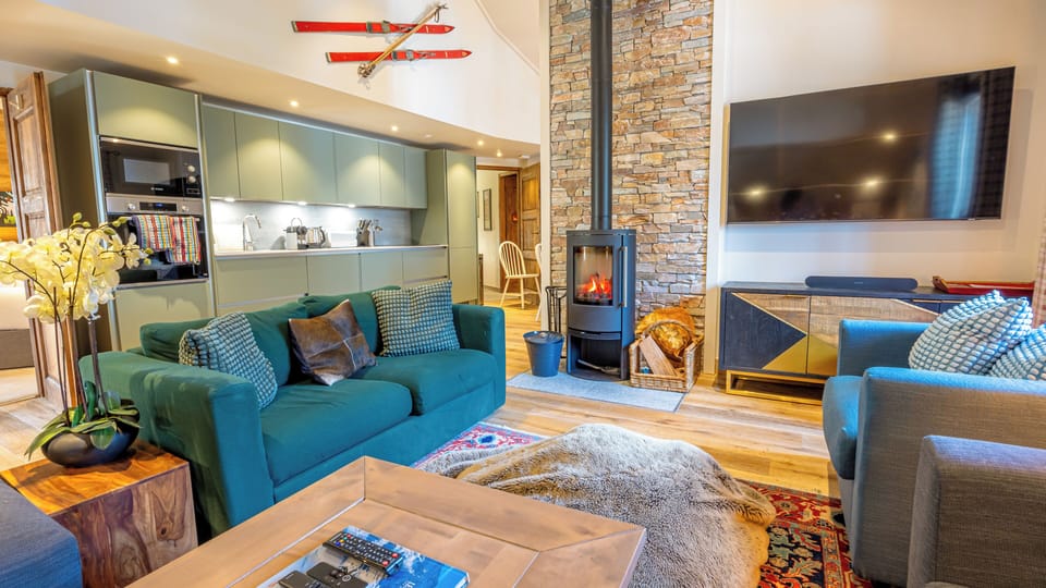 Large living room with woodburning stove, sofabed and TV