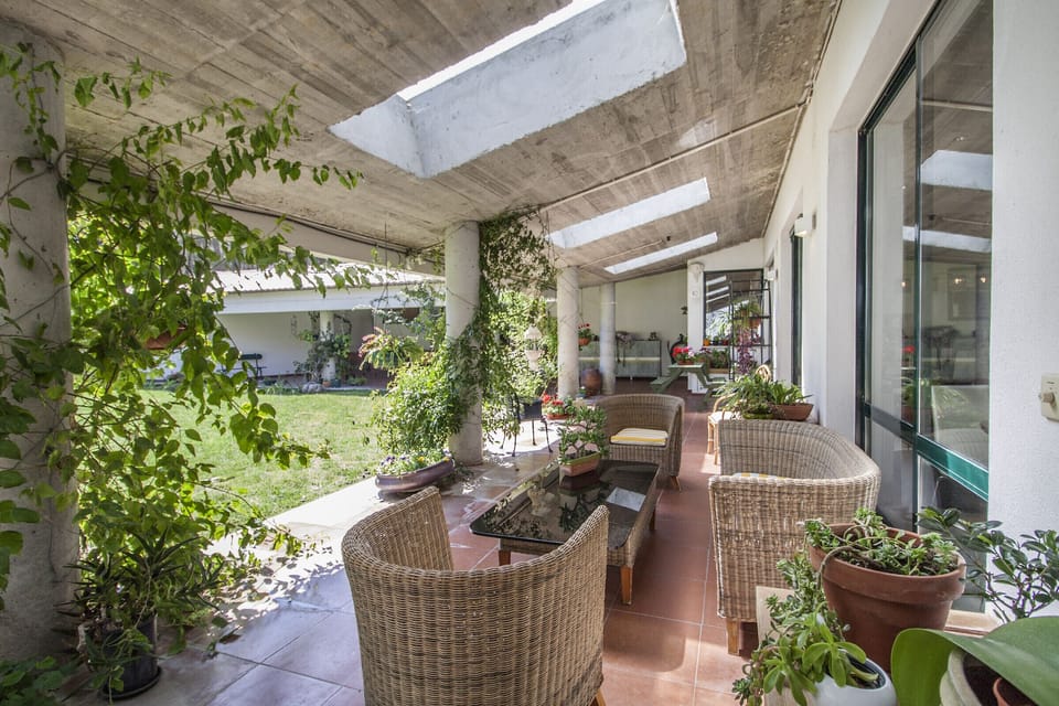 Covered terrace with wicker seating and climbing vines — Villa do Cisne, holiday villa in Herdade de Aroeira