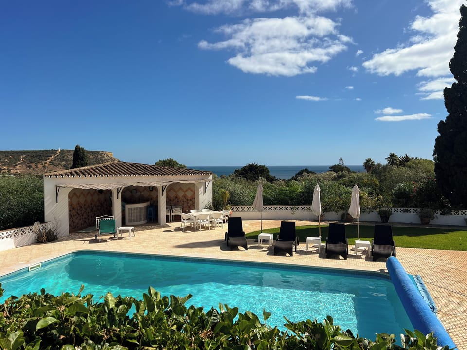 Heated pool with sun loungers and bar area