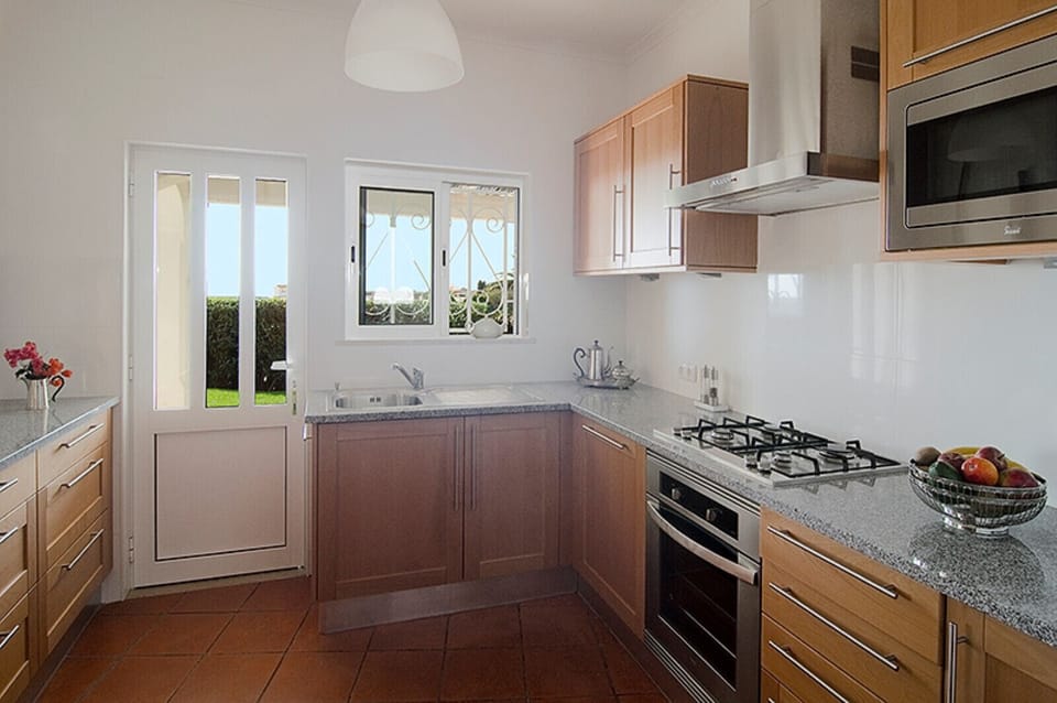Villa Camena: the modern kitchen with beautiful wooden front is equipped with a gas cooker, oven, dishwasher and microwave. A door leads directly onto the terrace.