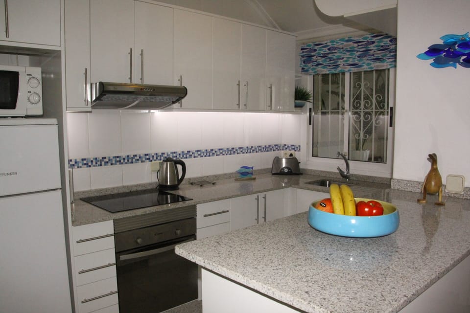 A spacious and well equipped kitchen with granite work surfaces.