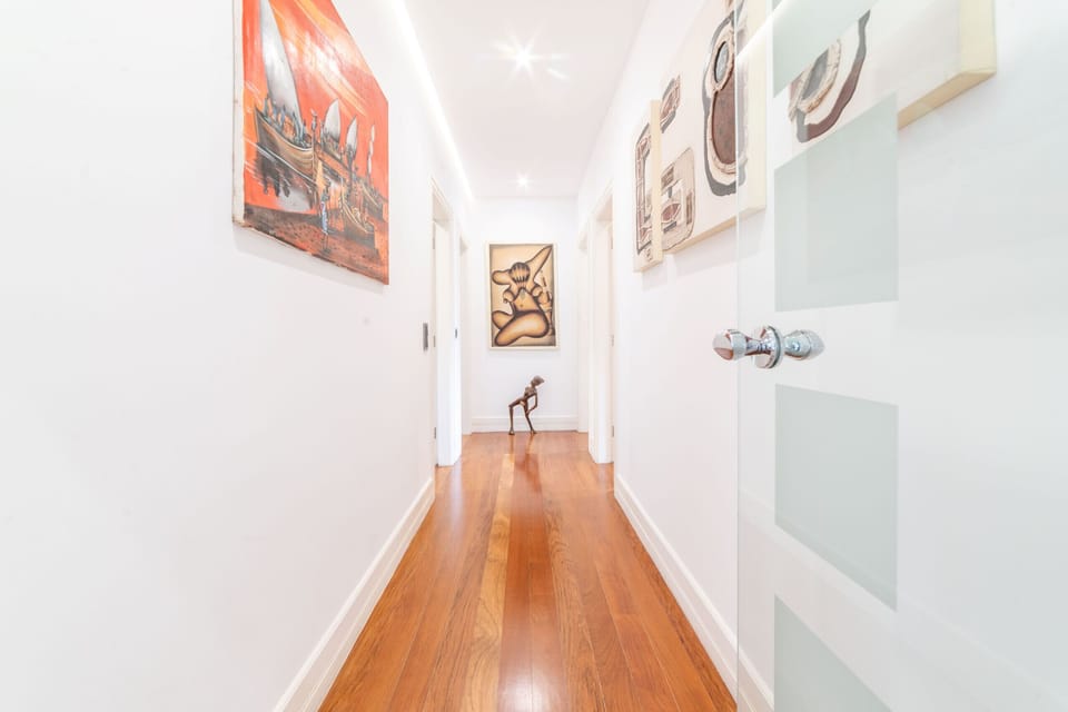 Contemporary hallway with artwork and wooden flooring — Villa dos Narcisos, holiday villa in Herdade de Aroeira