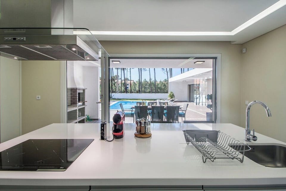Modern kitchen with island and pool view — Villa do Moinho II, holiday villa in Verdizela
