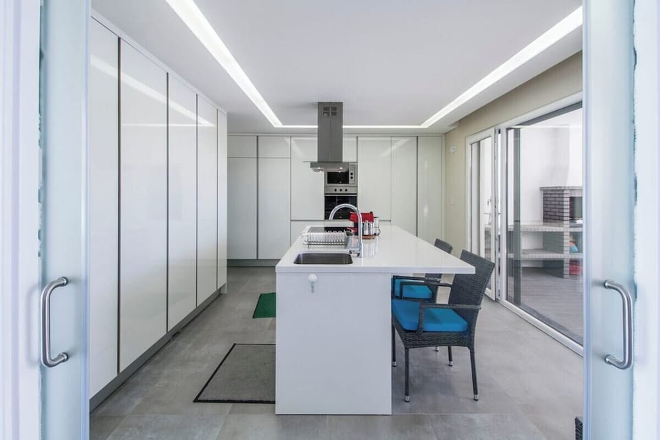 Modern kitchen with white island and integrated appliances — Villa do Moinho II, holiday villa in Verdizela