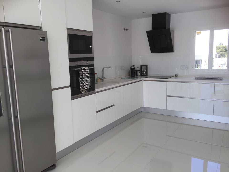 Fully equipped white high gloss kitchen with utility room to rear