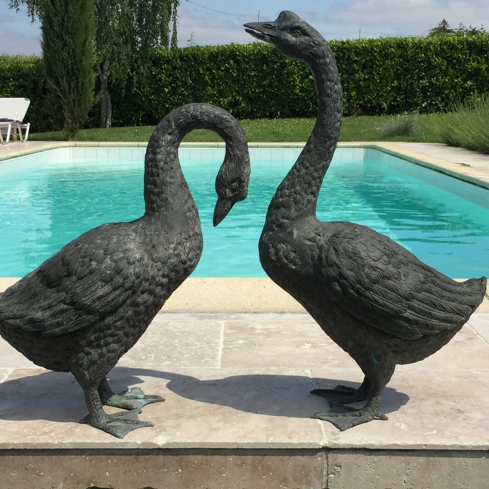Large private heated pool with travertine stone surround, sunbeds and parasols.