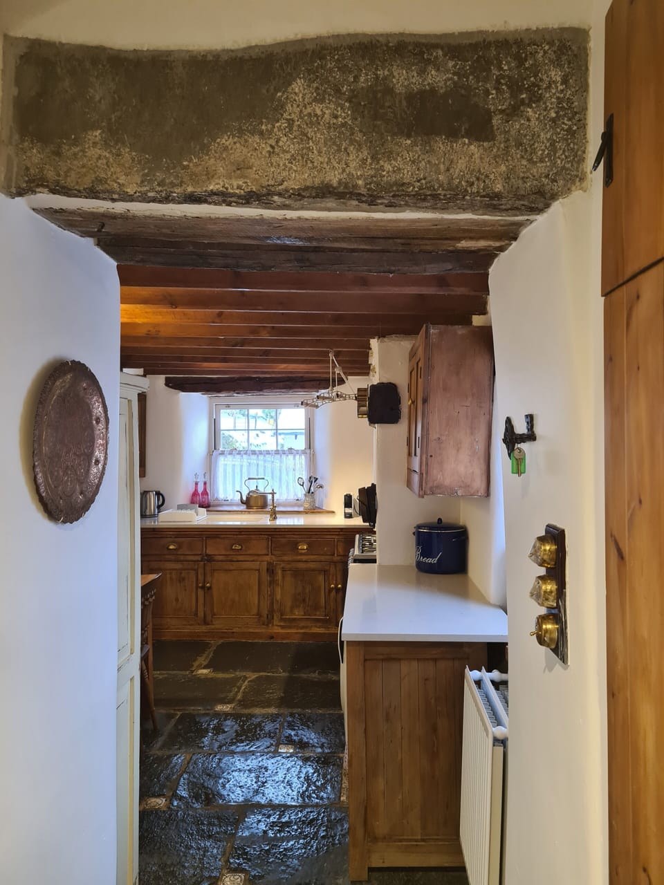 Entrance to kitchen with coat hanging area and boot rack.