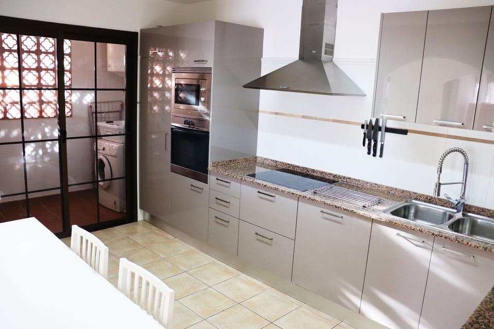 Kitchen with oven, hob, fridge freezer, microwave, dishwasher, washing machine.