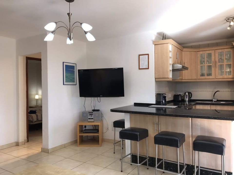 Open plan living with view to second bedroom, leading to main bathroom.