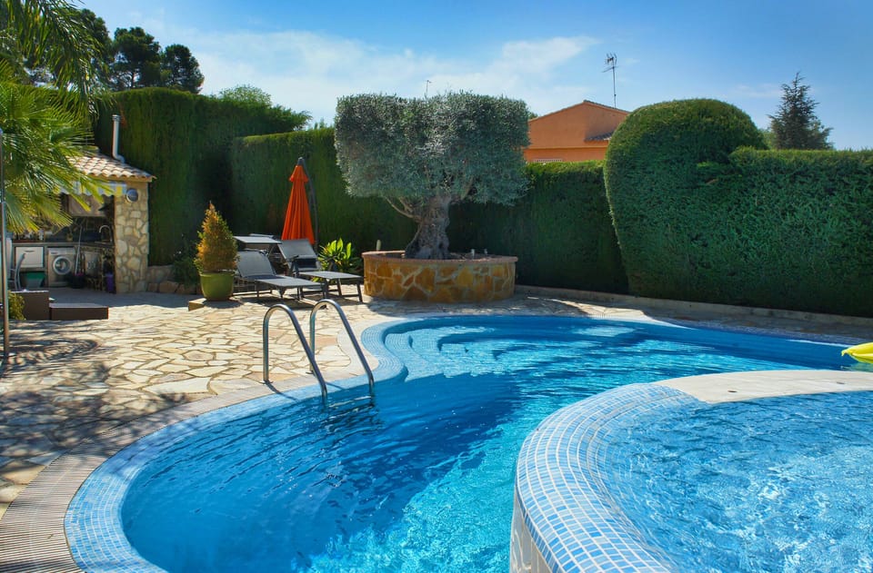 Pool and jacuzzi waterfall with outdoor kitchen