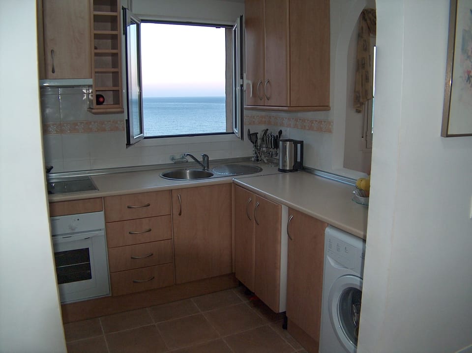 Kitchen with sea and pool view