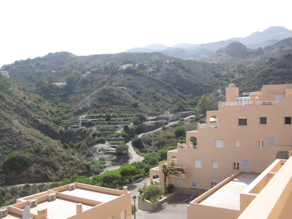 Side view of apartment which shows views of pool, sea and mountains, 