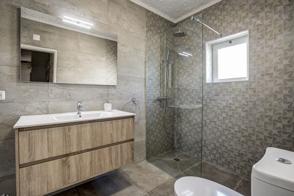 Luxurious wet room with oversized sink unit and rainfall shower.