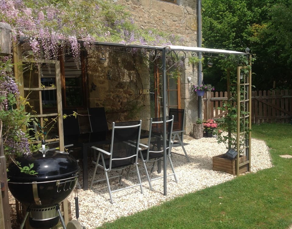 covered seating area outside the gite with table and chairs for 6
