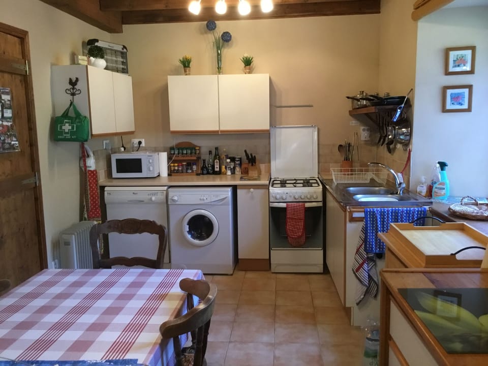 Kitchen showing table for 6, cooker, dishwasher and washing machine
