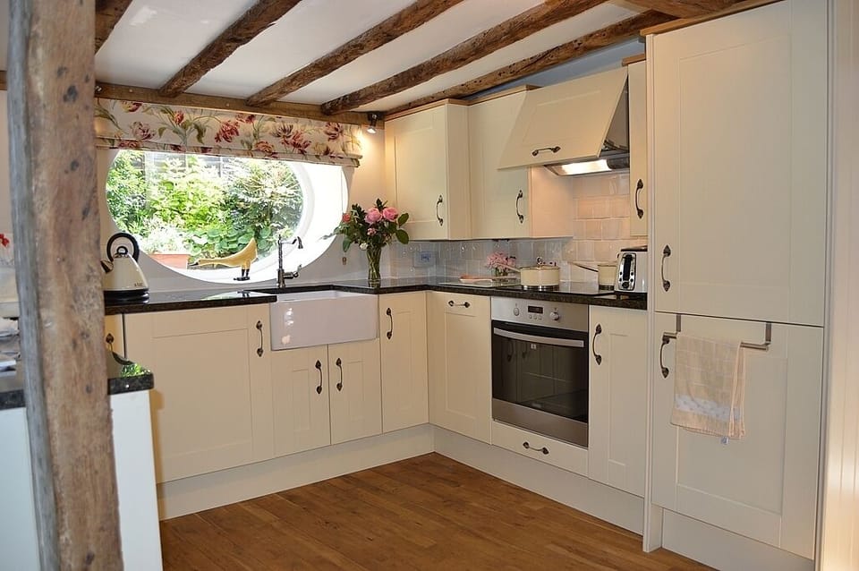 View to kitchen from dining room with oven, induction hob, dishwasher & washer