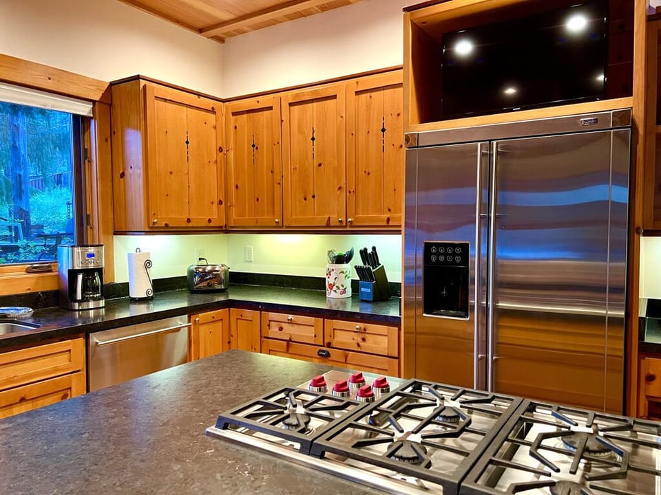 Fully equipped kitchen has a Wolf cooktop and GE Monogram appliances.