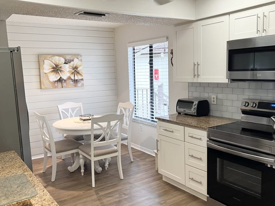 Eat-in kitchen and breakfast bar stools offer dining options.