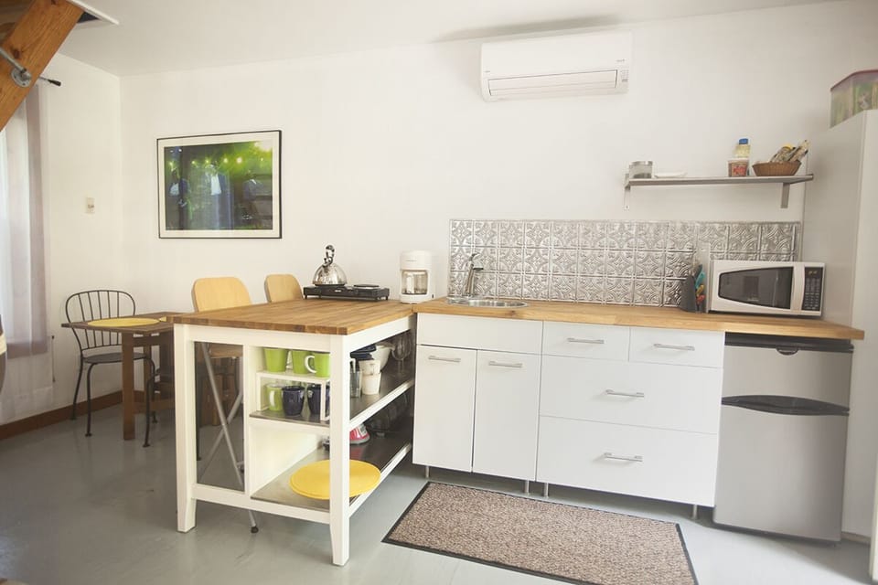 The modern and sleek kitchenette features butcher block countertops.
