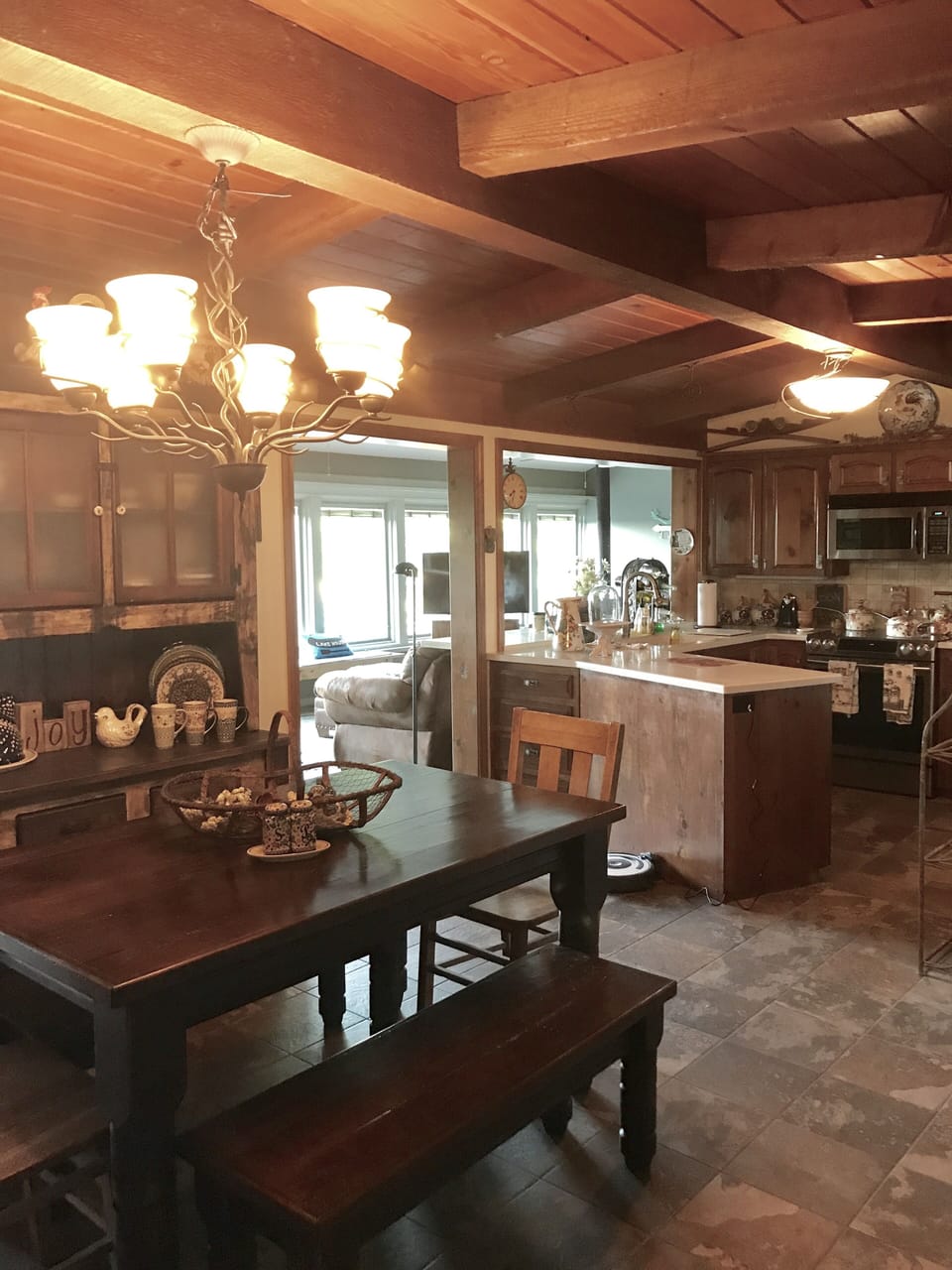 Dining room with farm table and hutch adjacent to kitchen, den, and lake room