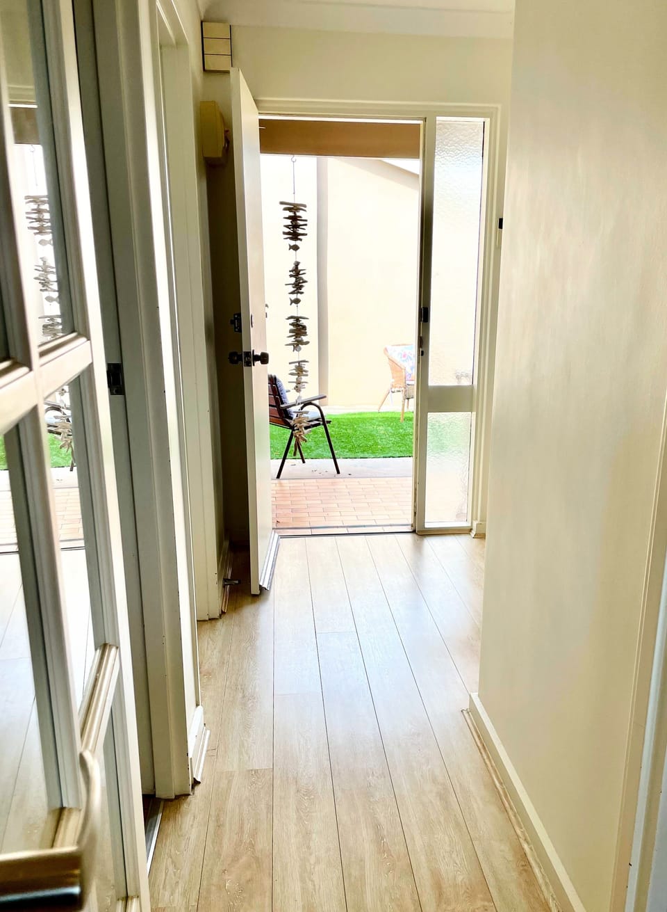 Hallway from dining room to rear courtyard. Bathroom and Bedroom 2 to the left. 