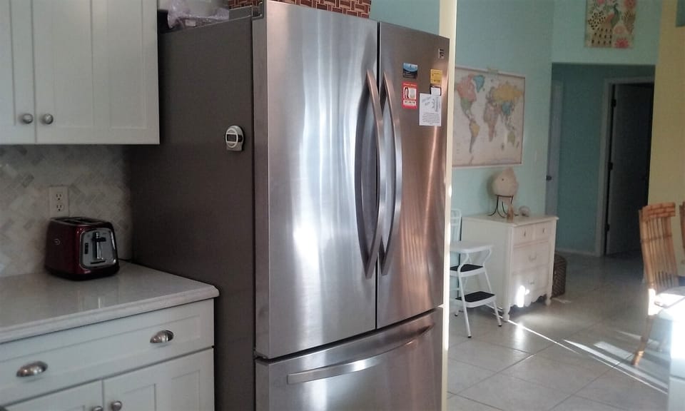Large new refrigerator, with ice maker and freezer on the bottom.