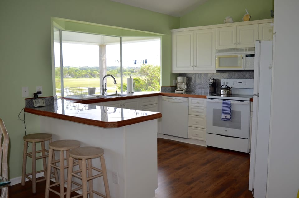 Fully equipped kitchen and bar stool seating for three.
