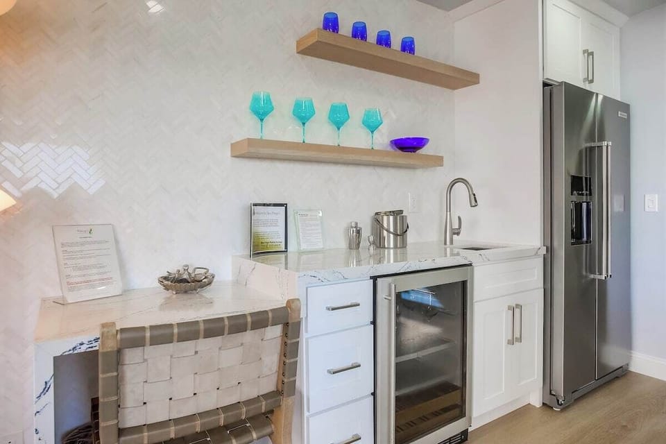 Wet bar next to the kitchen with wine refrigerator and desk space