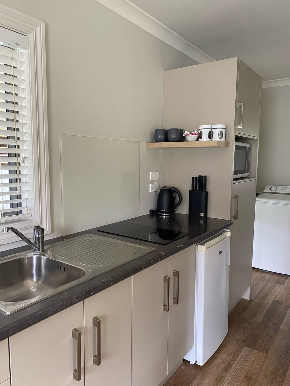 Fully equipped kitchen with cooktop, fridge, microwave 