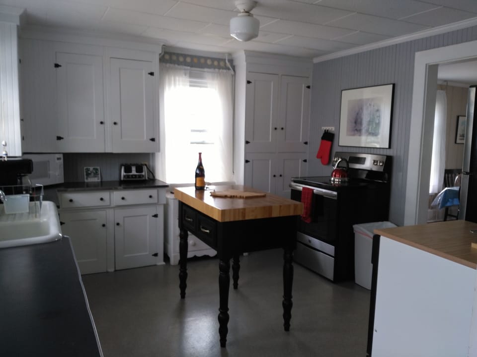 The kitchen is not new, but it is stocked with plenty of dishes, pots, pans, etc