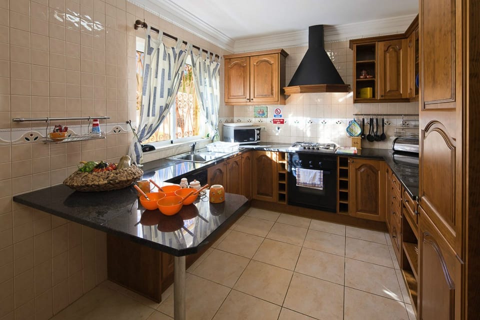 Fully equipped kitchen with breakfast table & chairs, with window overlooking garden & pool, also with door to pool terrace.