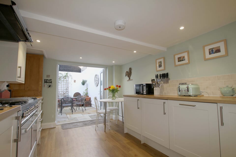 Kitchen leads through double doors to courtyard garden.