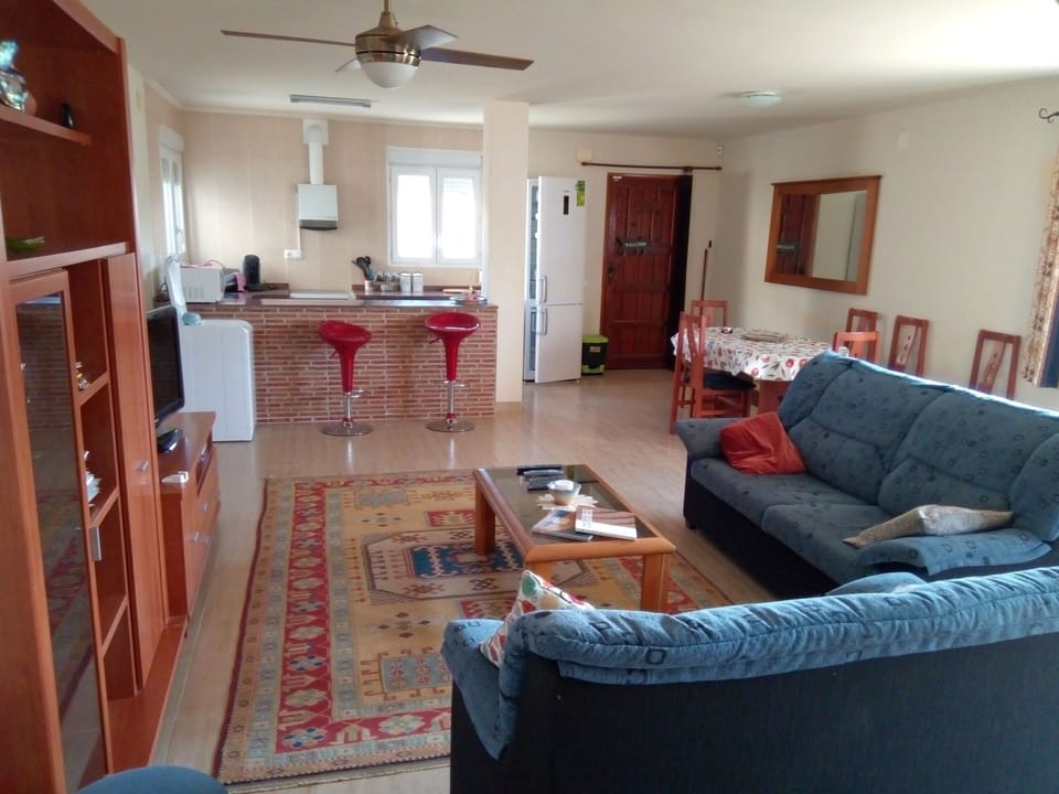 Seating and dining area, with tv on wall unit, looking toward  the kitchen