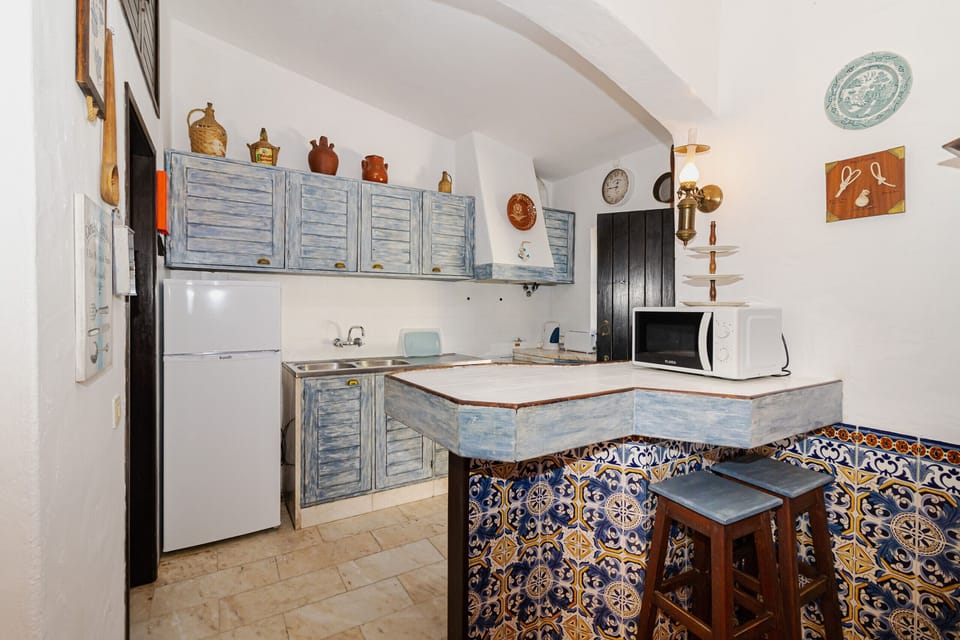 Rustic kitchen with blue cabinetry and decorative tilework — Villa Alice, holiday villa in Albufeira