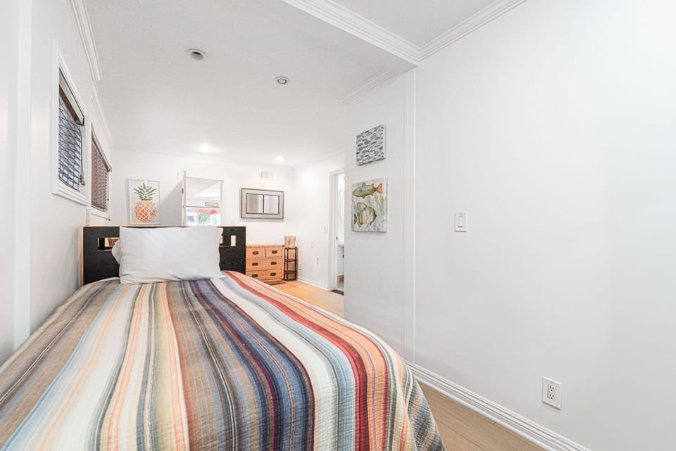The first guest bedroom is located on the main floor and includes two twin beds, an en suite bathroom, and an access door to the garage.
                