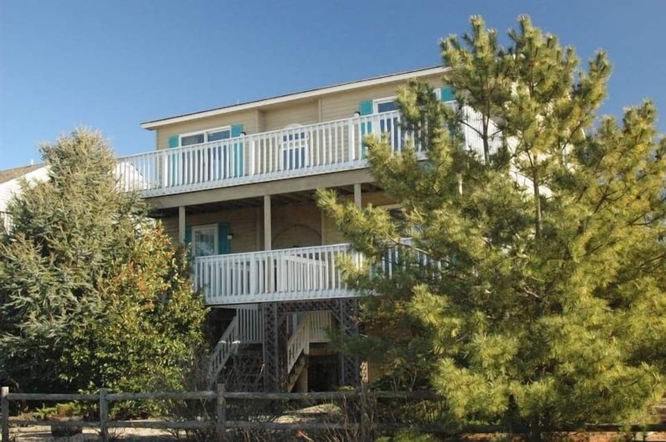 Front of house with upper and lower decks facing bay