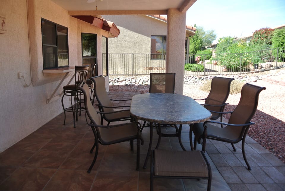 Back patio with large table, chairs, bar and bar stools 