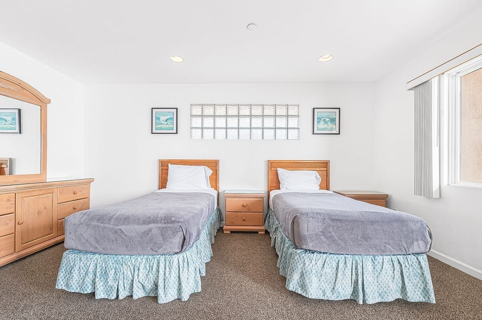Primary bedroom includes 1 Queen bed and 2 twin beds. There is also access to a large rear balcony deck.
                
