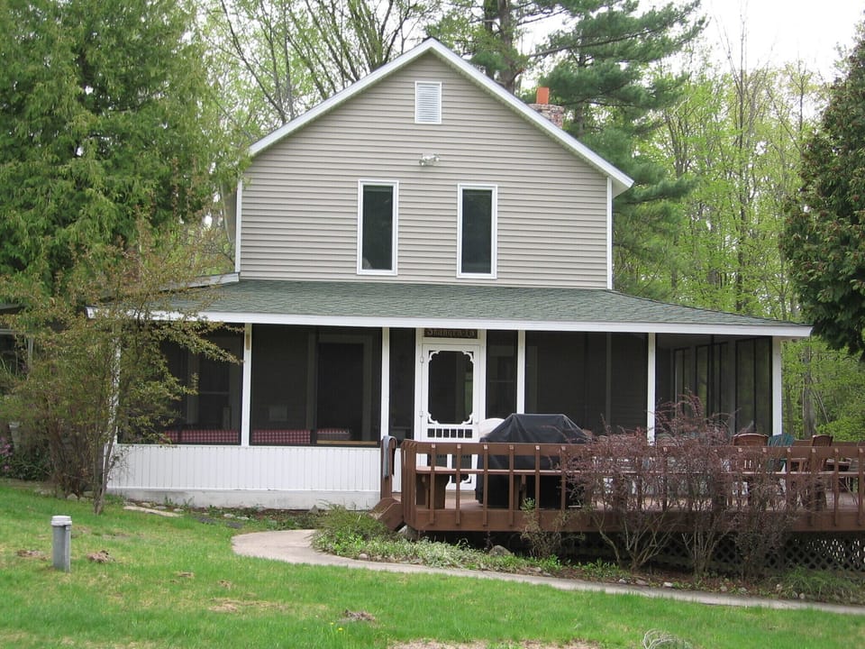 View of the porch from the yard. Big grill and outdoor seating on the porch.
