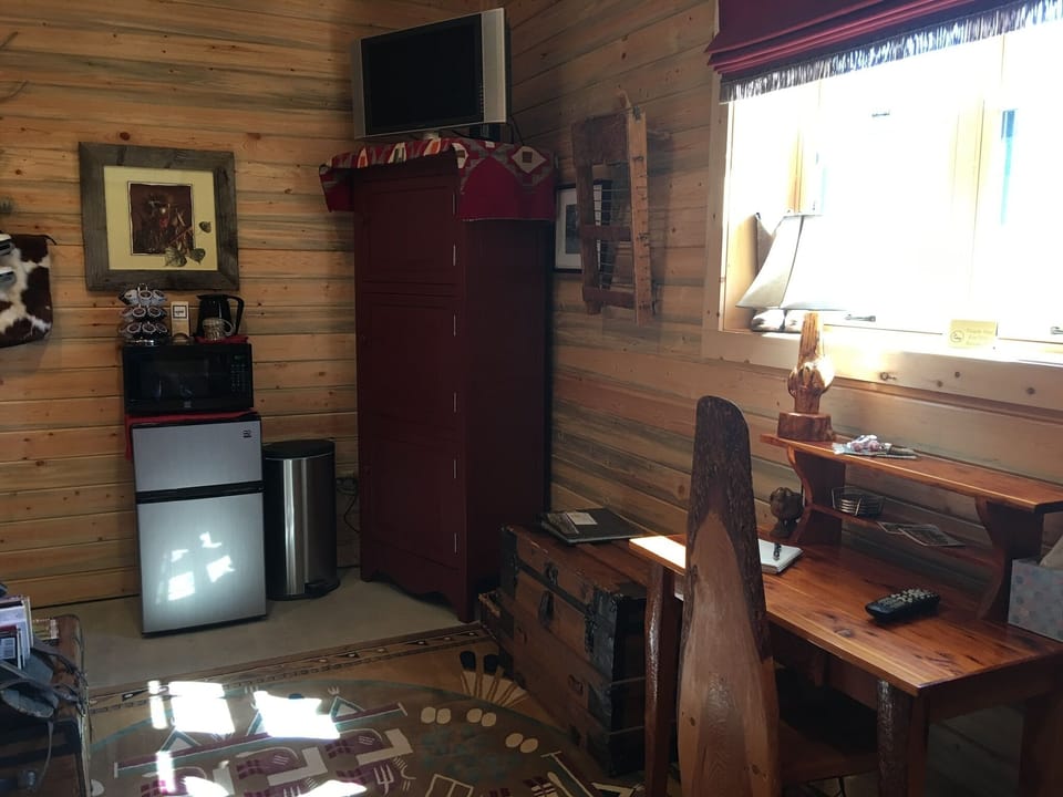 Refrigerator, Microwave, TV, and Desk in room.