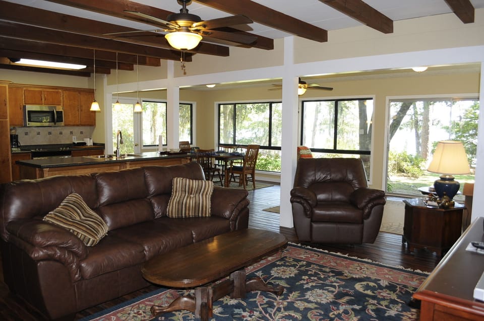 Big open floor plan with new leather furniture and recliner in front of TV
