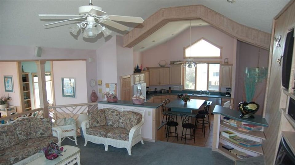 Raised Living Area with entertainment center to right and Kitchen in background