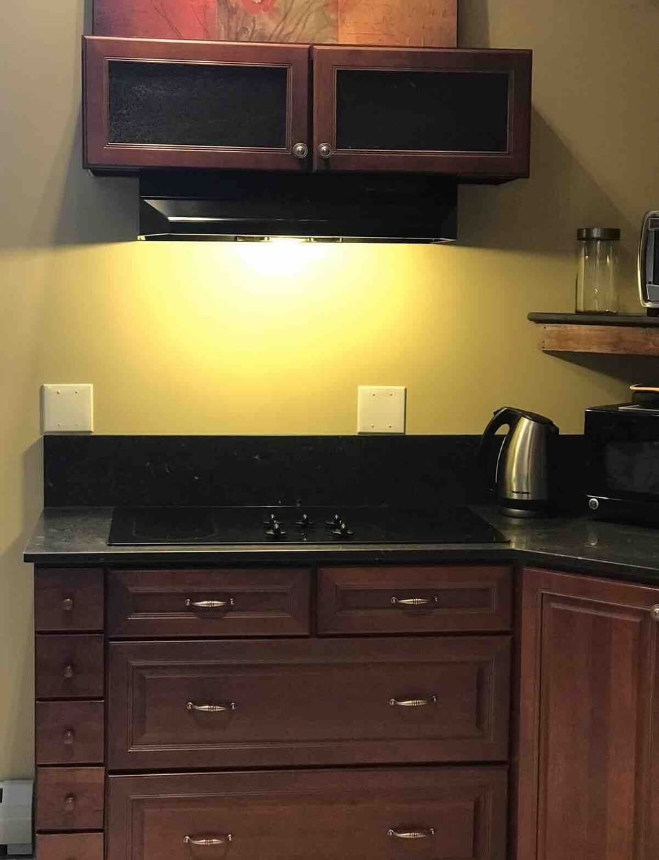 Kitchenette with cherry wood cabinets and marble counter