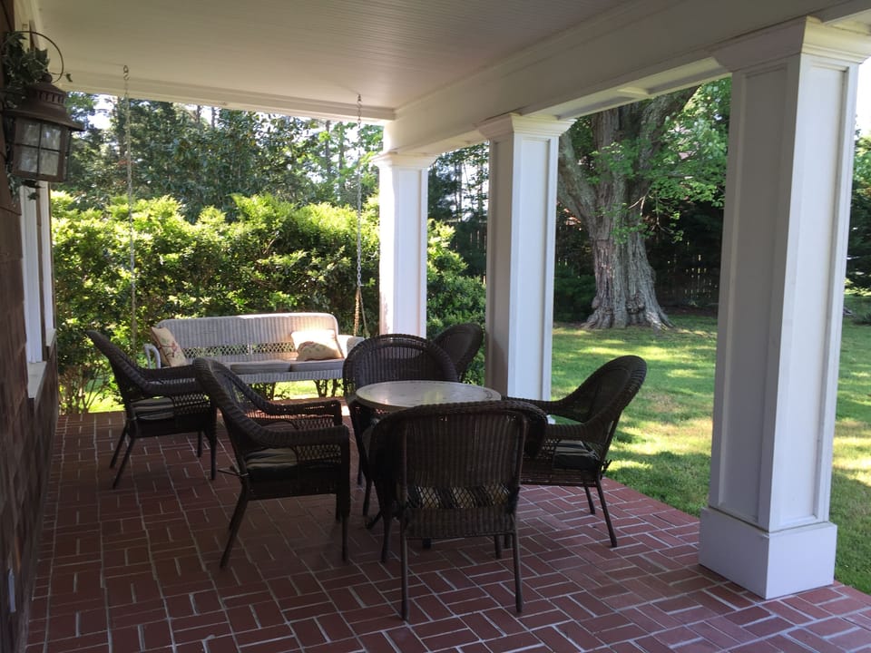 The waterfront porch with wicker chairs for eight.  Dibs on the porch swing !