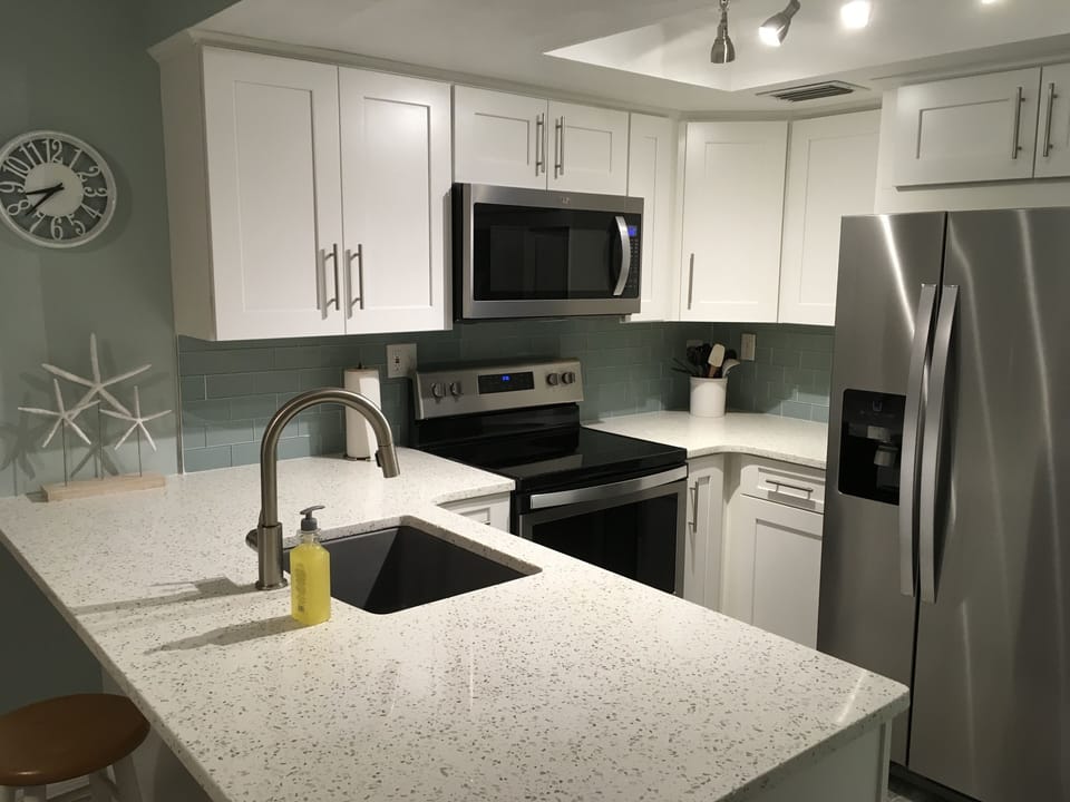 Brand new kitchen with quartz countertops and stainless appliances.