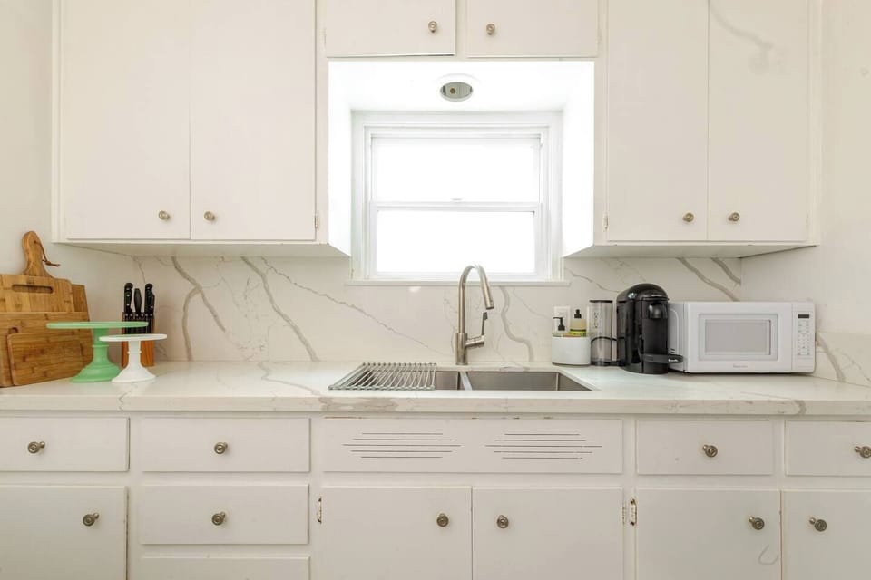 Kitchen with quartz counters and stainless steel deep sink.  Fully appointed.